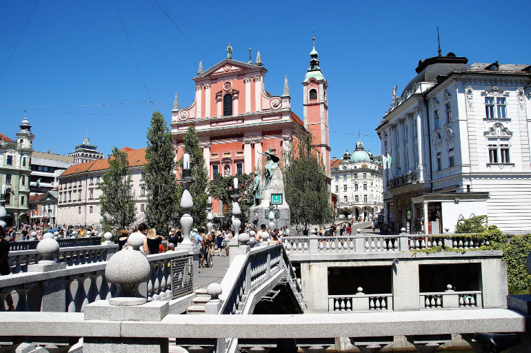 triple puente de ljubljana con la iglesia de la anunciación de fachada rosa